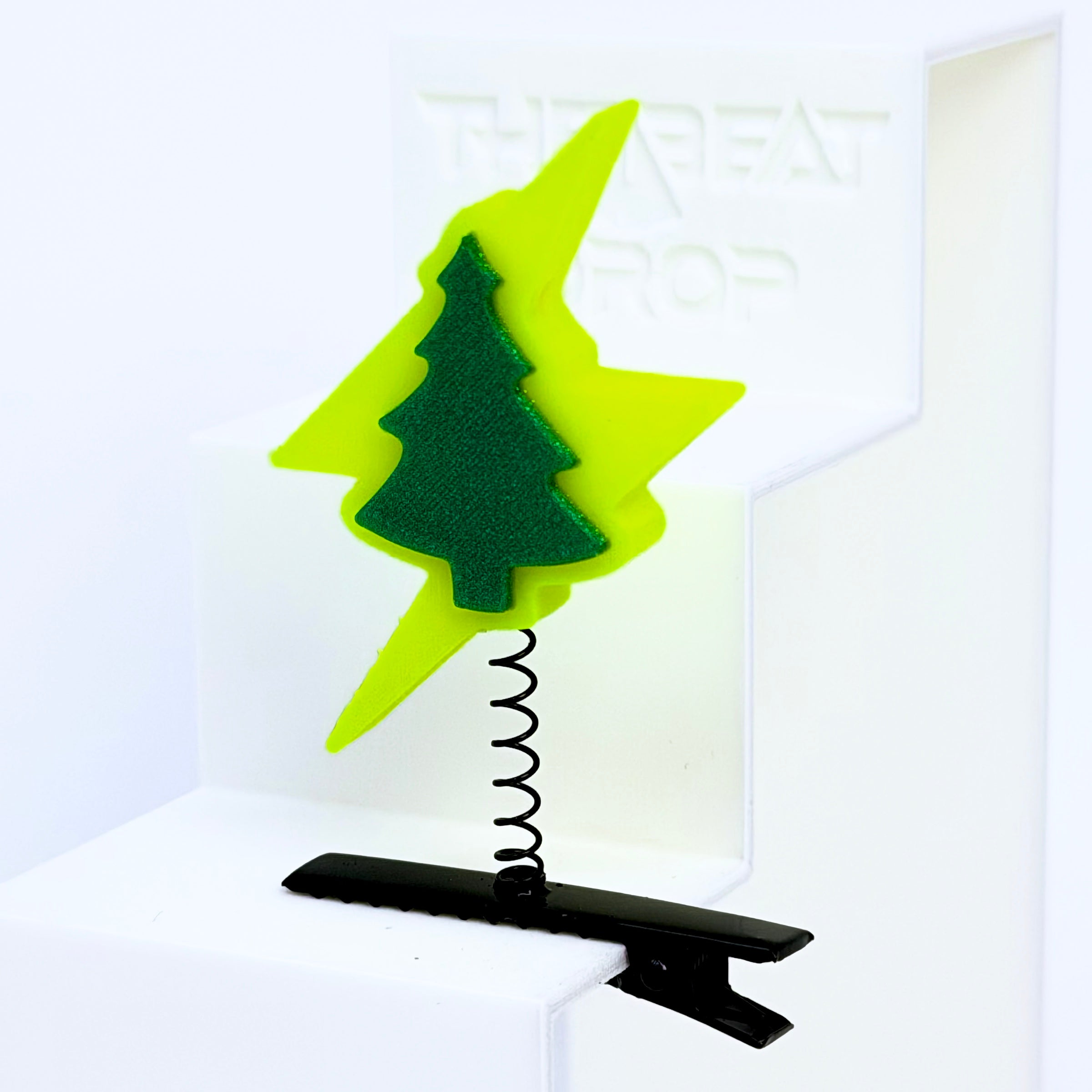 Close-up of Electric Forest lightning bolt rave sprout in neon yellow-green with forest green textured pine tree, mounted on black metal spring hair clip