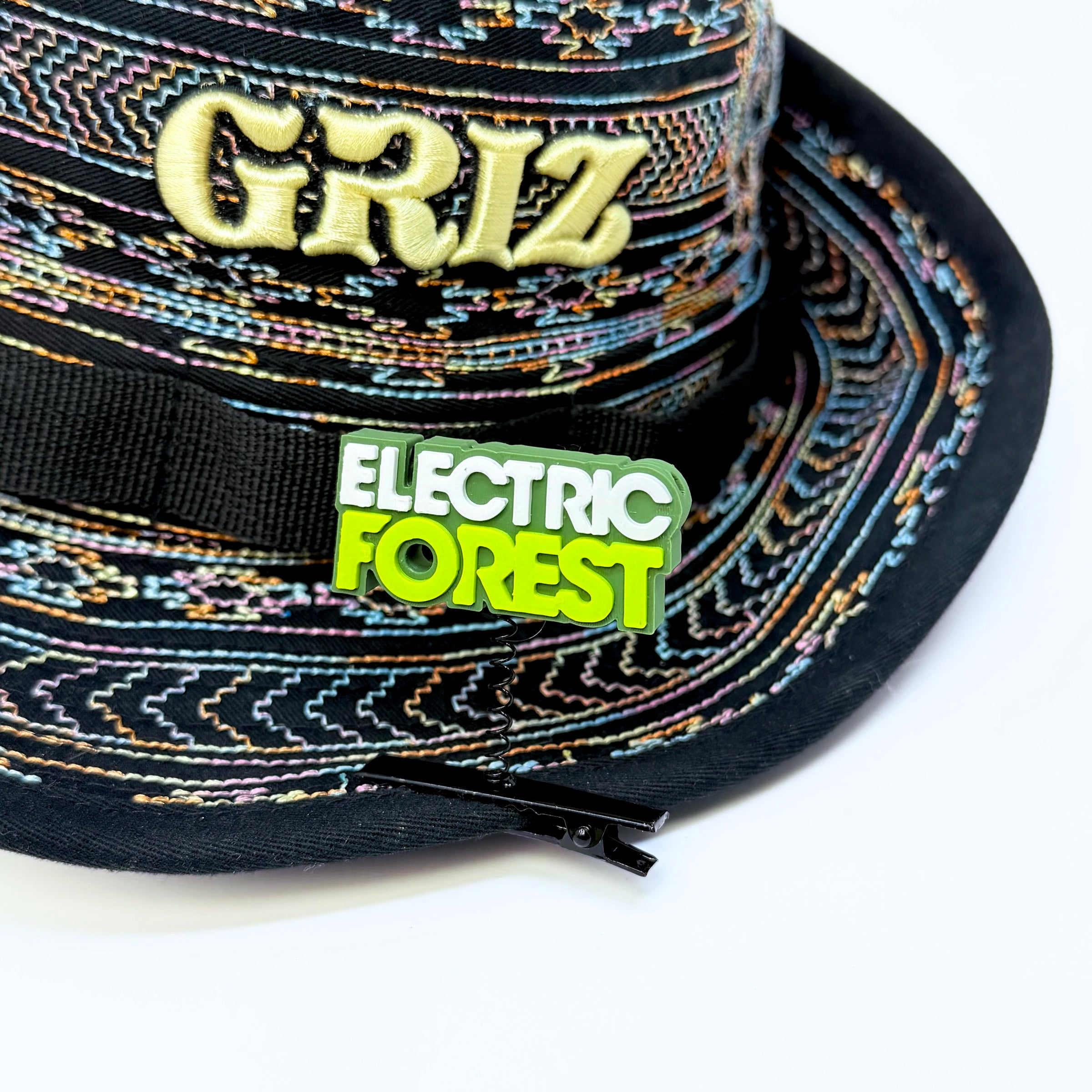 Electric Forest text rave sprout in dark green, white, and neon green clipped to the brim of a GRiZ festival bucket hat