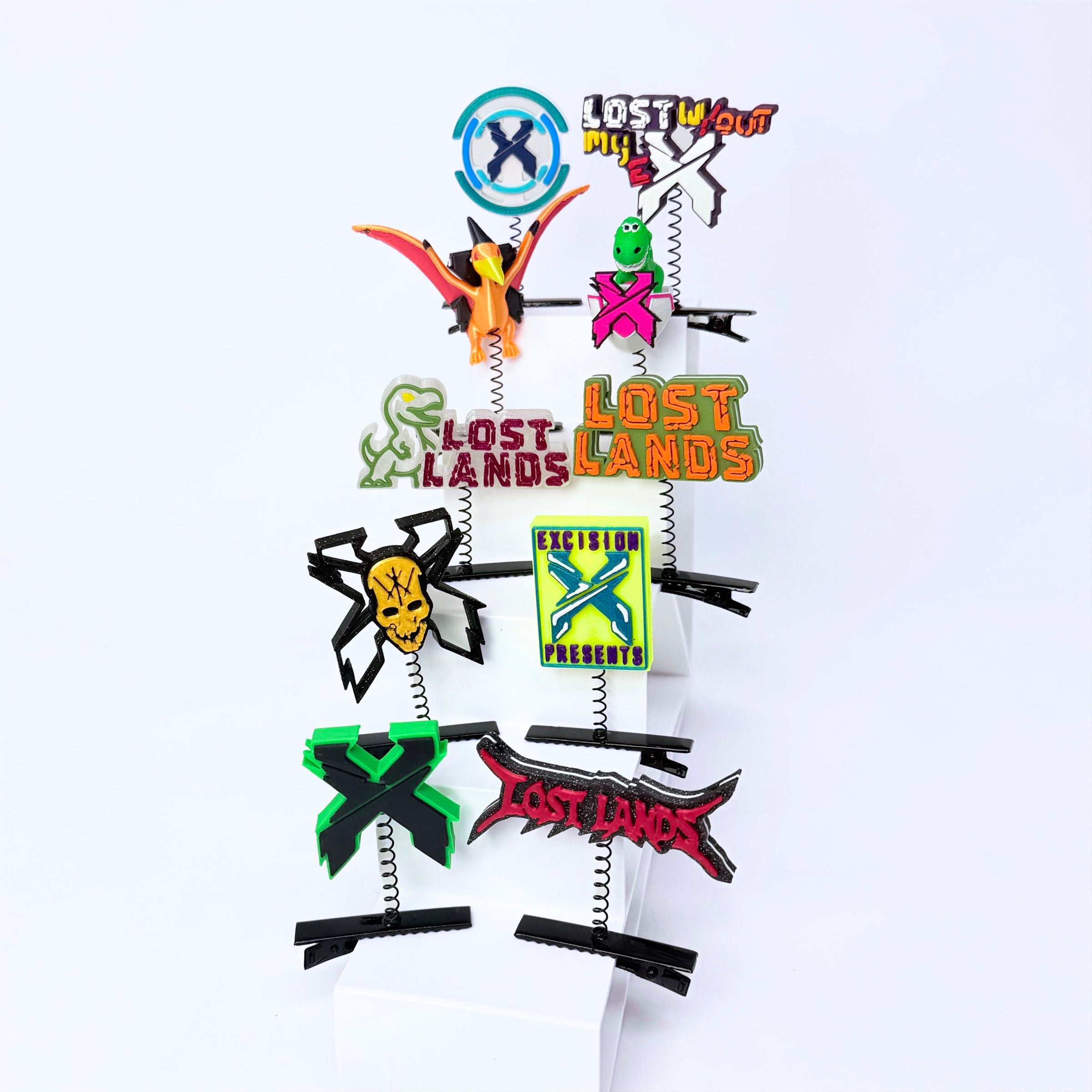 A set of eight Lost Lands-themed sprout clips arranged on a white display stand against a white background. The clips feature various character designs and logos.